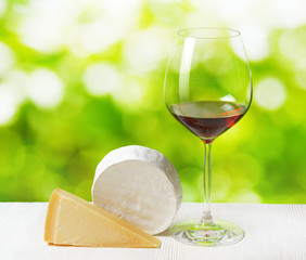 Canvas Print - Cheese and glass of wine on nature background