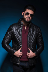 Poster - young man with long beard is holding his leather jacket