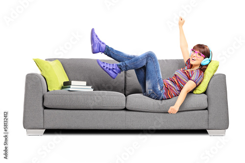 Naklejka na szybę Nastolatka słuchająca muzyki na kanapie