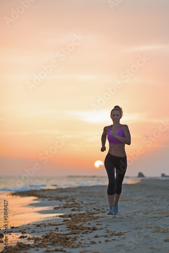 Naklejka - mata magnetyczna na lodówkę Fitness young woman running on beach in the evening