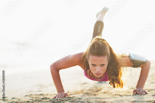 Foto-Stoff bedruckt - Female athlete doing push ups on beach (von Alliance)