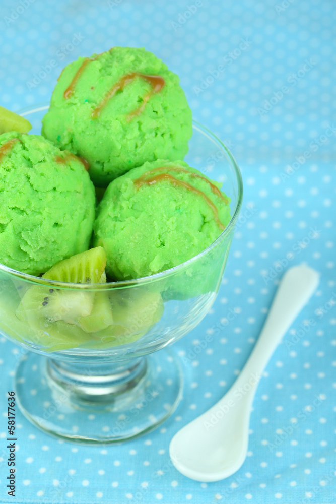 Delicious ice cream on glass vase on blue tablecloth