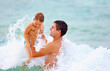 © Olesia Bilkei - playful father and son having fun in water