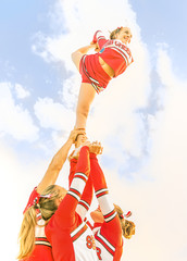 Wall Mural - Young cheerleader balancing toward the Sky - Cheerleaders Team