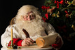 © Milles Studio - Santa Claus sitting at home and writing on old paper roll to do