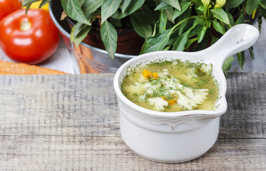 Wall Mural - Chicken soup with vegetables on wooden table. Copy space