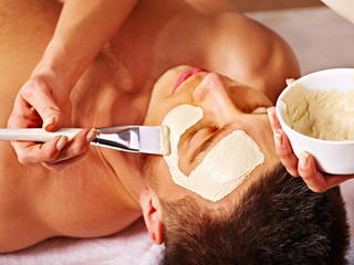 Clay facial mask in beauty spa.