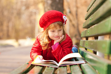 happy smiling little girl reading interesting book
