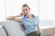© lightwavemedia - Smart businesswoman sitting on couch holding her notebook