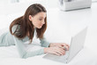 © lightwavemedia - Relaxed casual young woman using laptop in bed