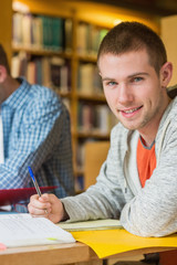 Canvas Print - Portrait of a smiling male student at library desk