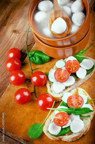 Board z aluminiowym obramowaniem Mozzarella, pomidory i chleb. 