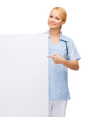 Poster - smiling female doctor or nurse with blank board