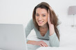© lightwavemedia - Relaxed casual smiling woman using laptop in bed