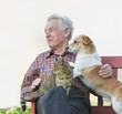 © Budimir Jevtic - Senior man wirh dog and cat on his lap in garden