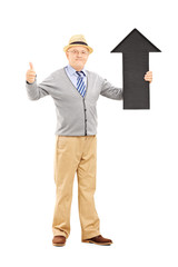 Poster - Smiling senior man holding arrow pointing up and giving thumb up