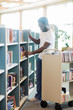 © Tyler Olson - Librarian Arranging Books In Shelf At Library