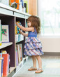 © Tyler Olson - Girl Choosing Book From School Library