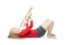 Young Girl In Red Playing Trumpet Laying Down
