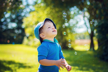 Child in the garden looking at soap bubbles