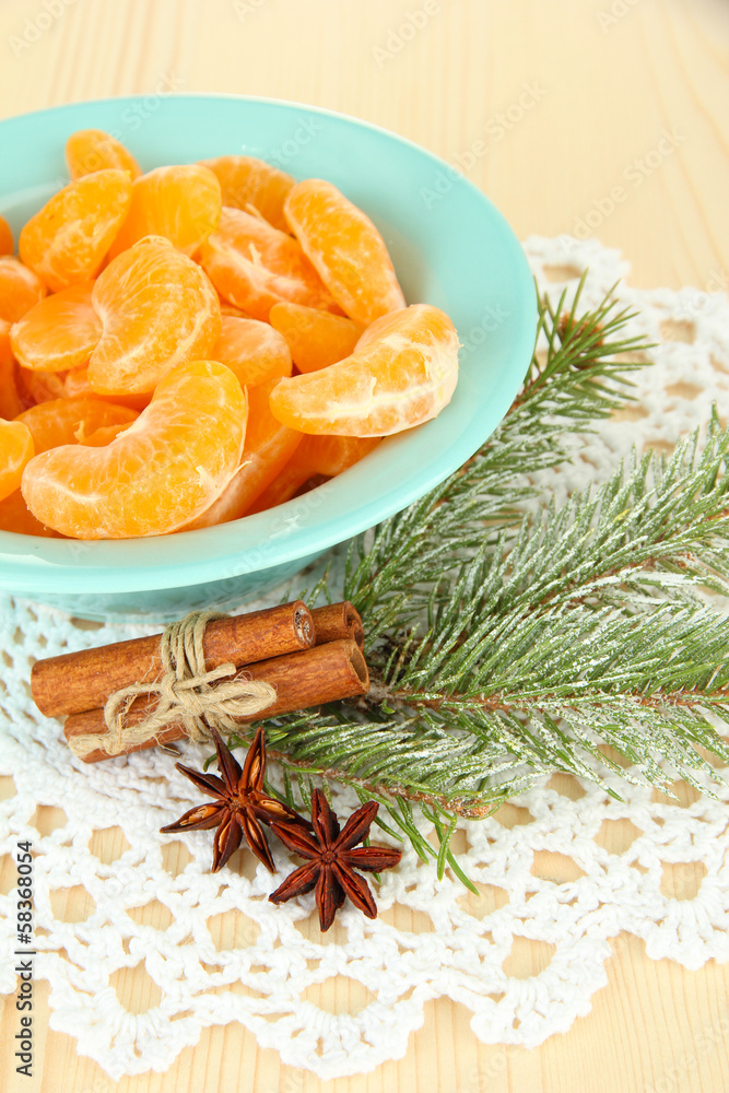 Tasty mandarine's slices on color plate on light background