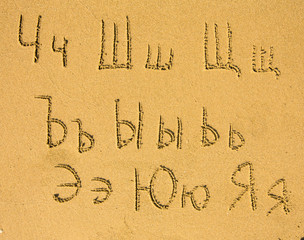 Wall Mural - Russian alphabet (from Ch to Ja) written on a sand beach.