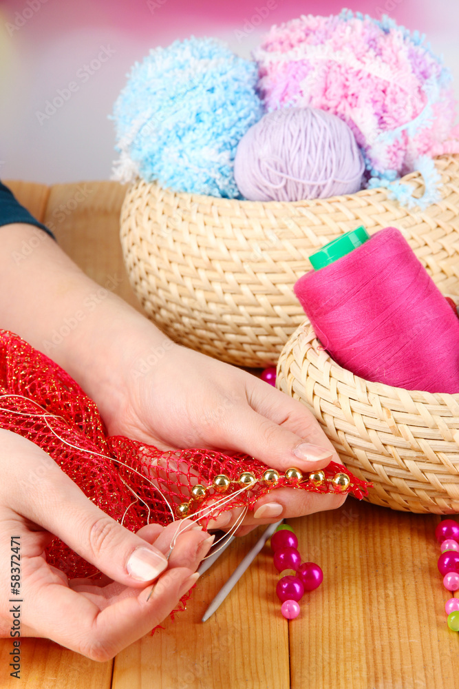 Decor fabric beads on wooden table on bright background