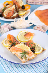 Sticker - Salmon sandwiches on plate  on wooden table close-up