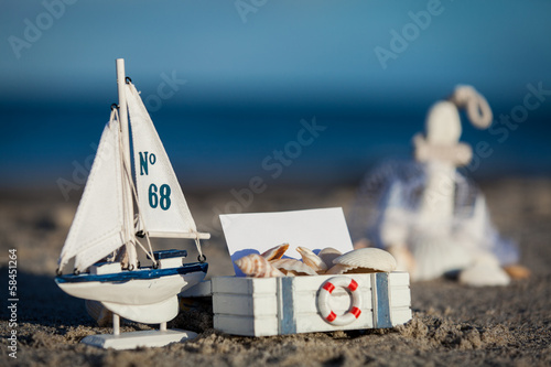 Fototapeta na wymiar segelboot und muscheln im sand dekoration urlaub