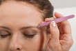 © juniart - nahaufnahme augenbrauen zupfen mit pinzette pflege