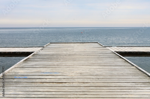 Board z aluminiowym obramowaniem Stare drewniane molo nad morzem