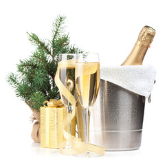 Champagne bottle in ice bucket, two glasses and christmas gift