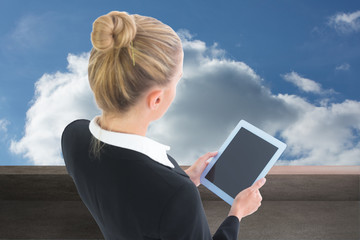 Poster - Composite image of businesswoman holding tablet