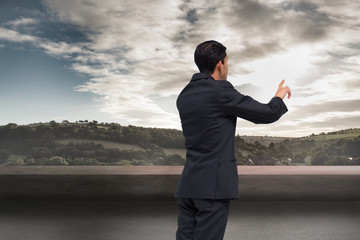 Poster - Composite image of thoughtful asian businessman pointing