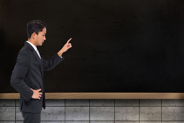 Poster - Composite image of unsmiling asian businessman pointing