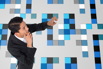 Poster - Composite image of thoughtful asian businessman pointing