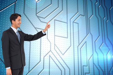 Poster - Composite image of smiling asian businessman pointing