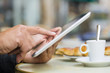 © ldprod - Man using a Tablet Pc on cafe terrace, croissant and coffee
