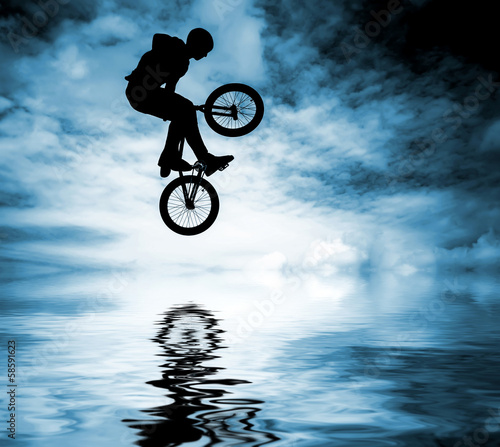 Fotoboard na płycie Sylwetka człowieka robi skok z rowerem bmx.