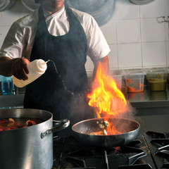 Chef cooking in kitchen stove