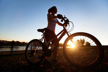 Silhouette Of Young Woman With Bicycle Outdoor