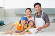 © lightwavemedia - Family of four preparing cookies in kitchen