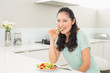 © lightwavemedia - Portrait of a young woman eating salad in kitchen