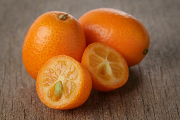 Wall Mural - ripe kumquat fruits on wooden table