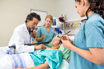 Wall Mural - Doctor And Nurses Examining Patient