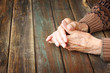 © tomertu - close up of elderly male hands on wooden table