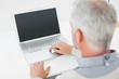 © lightwavemedia - Close-up rear view of a grey haired man using laptop at desk