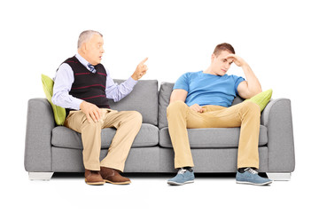 Wall Mural - Father reprimending his son seated on a couch