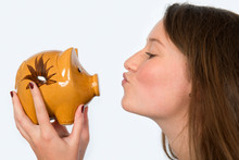 Young Woman Is Kissing Her Piggybank