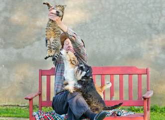 Wall Mural - Old man keeps the cat from dogs